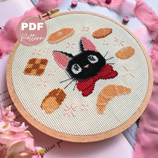 Embroidery hoop with a cat Jiji in kiki's deliver service design on a pink floral background