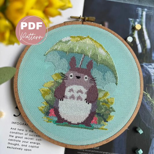 Embroidery hoop with cartoon character totoro holding an umbrella on a light blue background, with 'PDF Pattern' label.